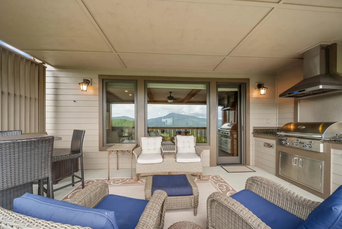 An inviting outdoor seating area with a grill and panoramic views of the mountains, designed for barbecuing, relaxing, and socializing. The relaxed and welcoming mood makes it an ideal setting for gatherings with friends or couples.