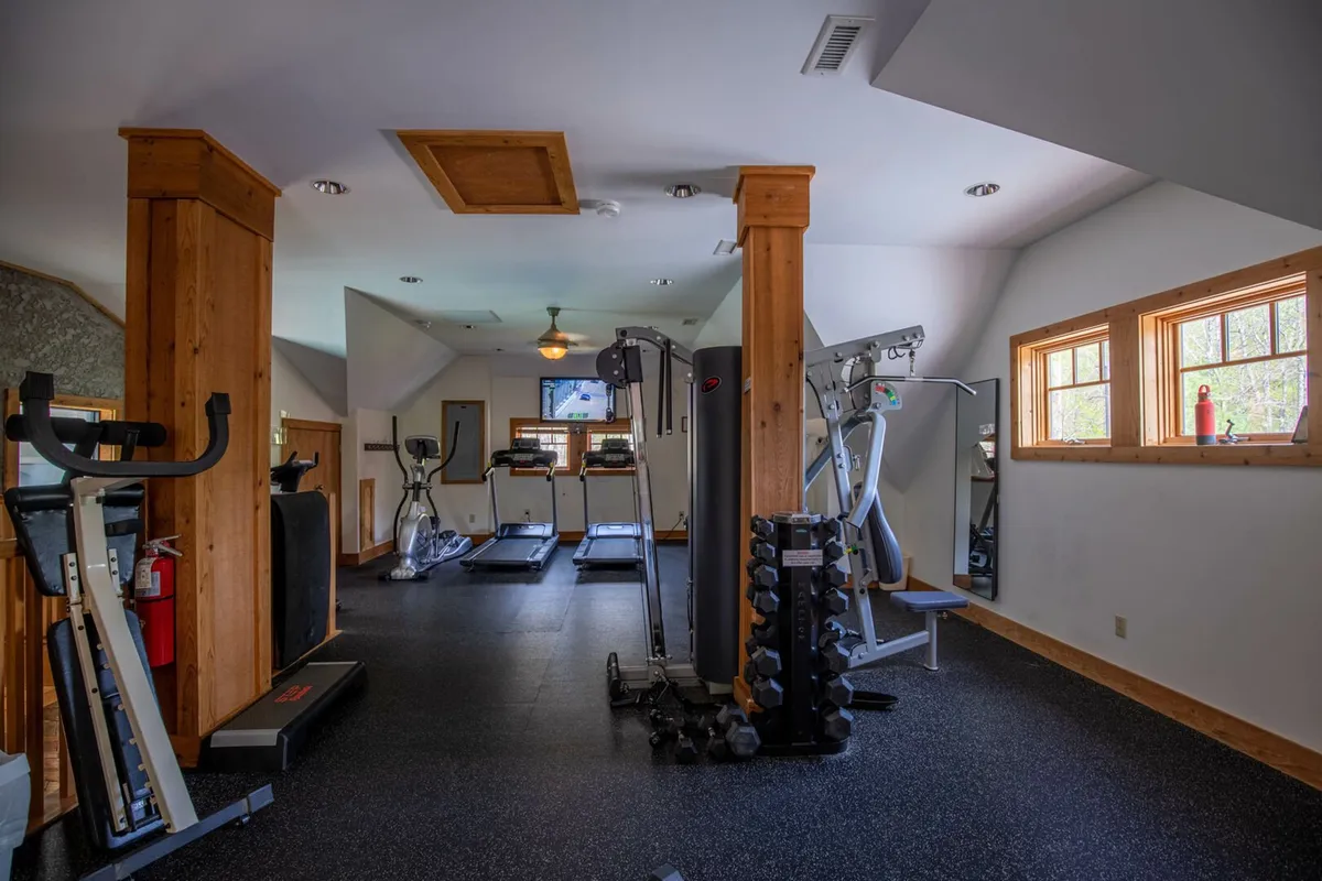 A bright fitness center with exercise equipment, mirrors, and windows that let in natural light. The motivational setting suggests opportunities for social workouts or fun group fitness sessions at the Echota Clubhouse.